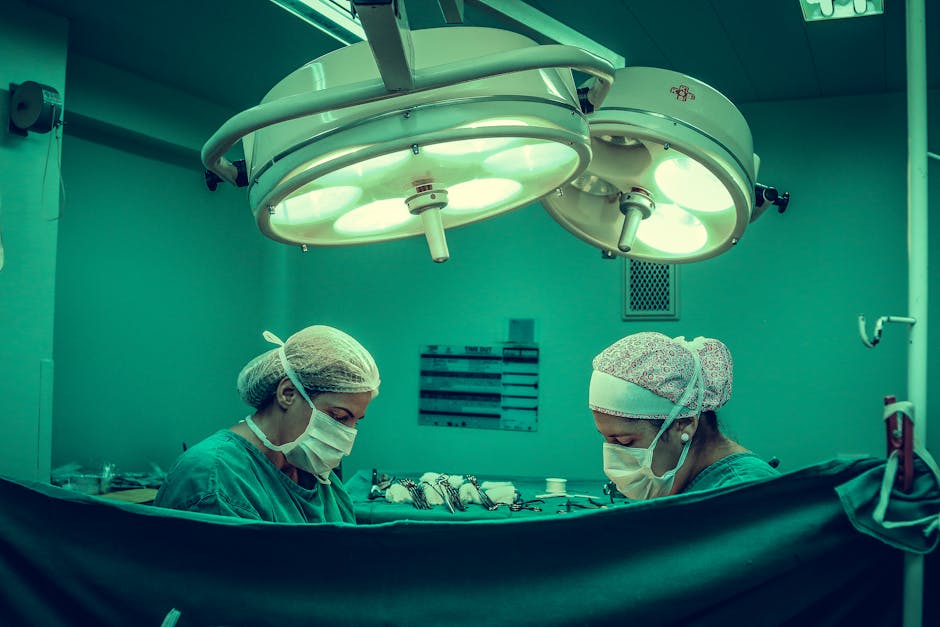 Surgeons in an operating room conducting a medical procedure under bright surgical lights.