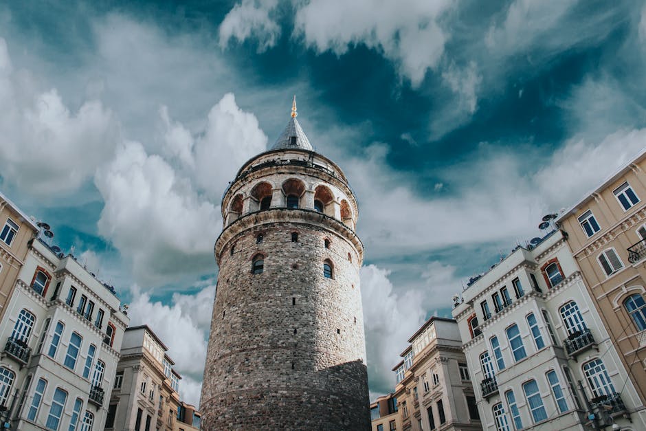 Captivating view of Galata Tower surrounded by historic architecture and dramatic clouds in Istanbul, Turkey.